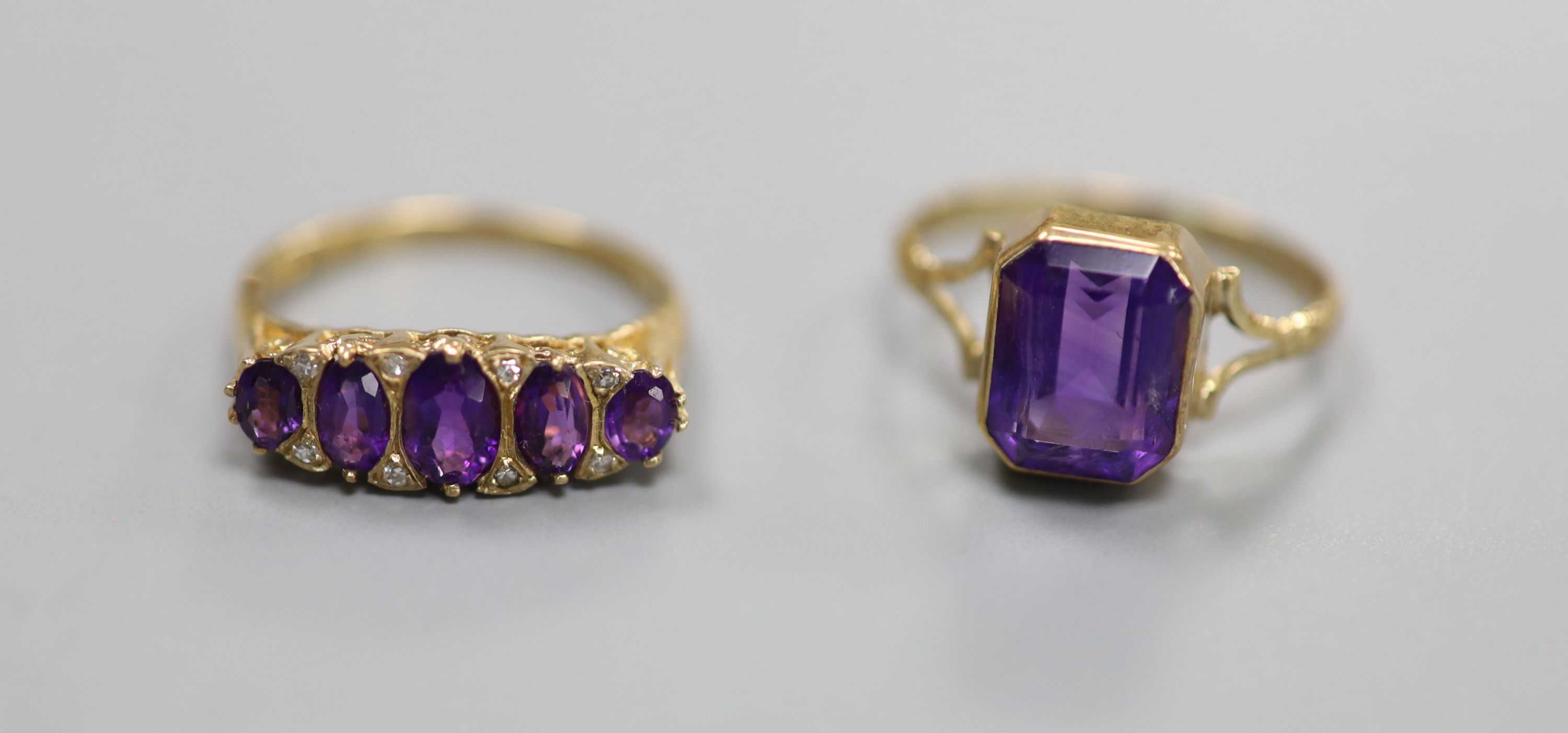 Three assorted 9ct and amethyst set dress rings, including amethyst and diamond and amethyst and seed pearl and one 9ct and amethyst paste ring.